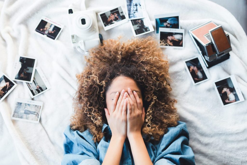 photo of woman with curly hair covering her face