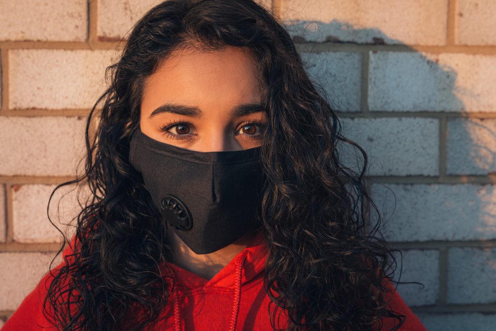 photo of a curly haired woman wearing a mask
